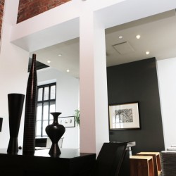 Appartement contemporain à dominante blanc et noir pour faire ressortir le mur de briques
